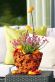 Texas-Flair auf den Tisch gezaubert mit einem Übertopf aus Drahtgeflecht und Pappmaché sowie gelben und roten Paprika, im Topf blüht Daboecia cantabrica von Juni bis Oktober.